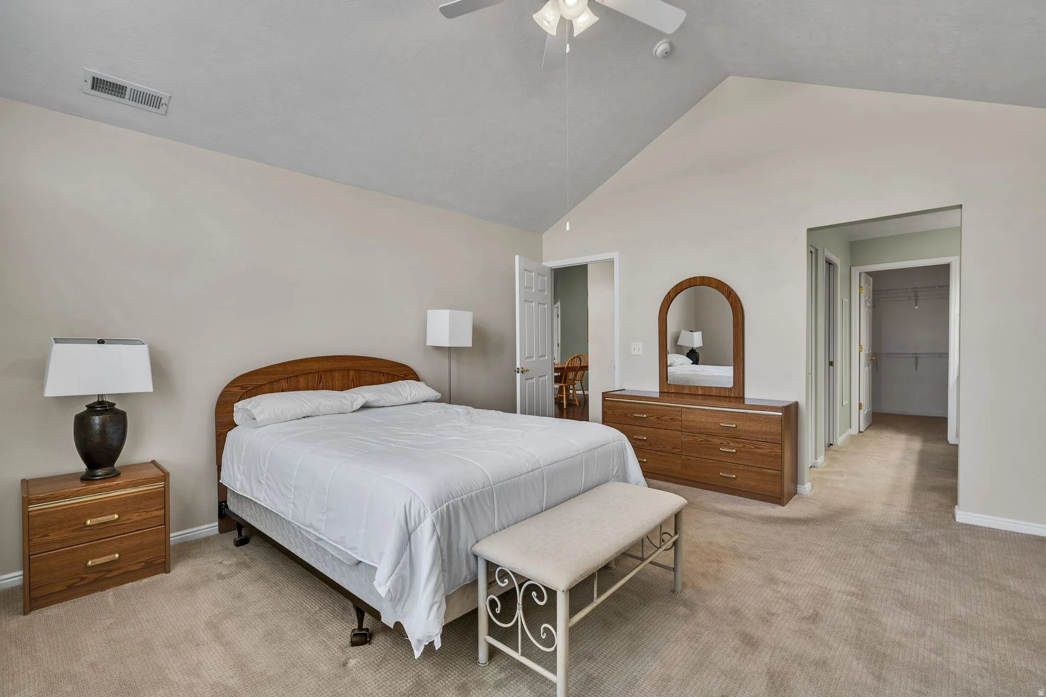 Primary Carpeted bedroom featuring a vaulted ceiling with ceiling fan, neutral wall tones, and recessed lighting