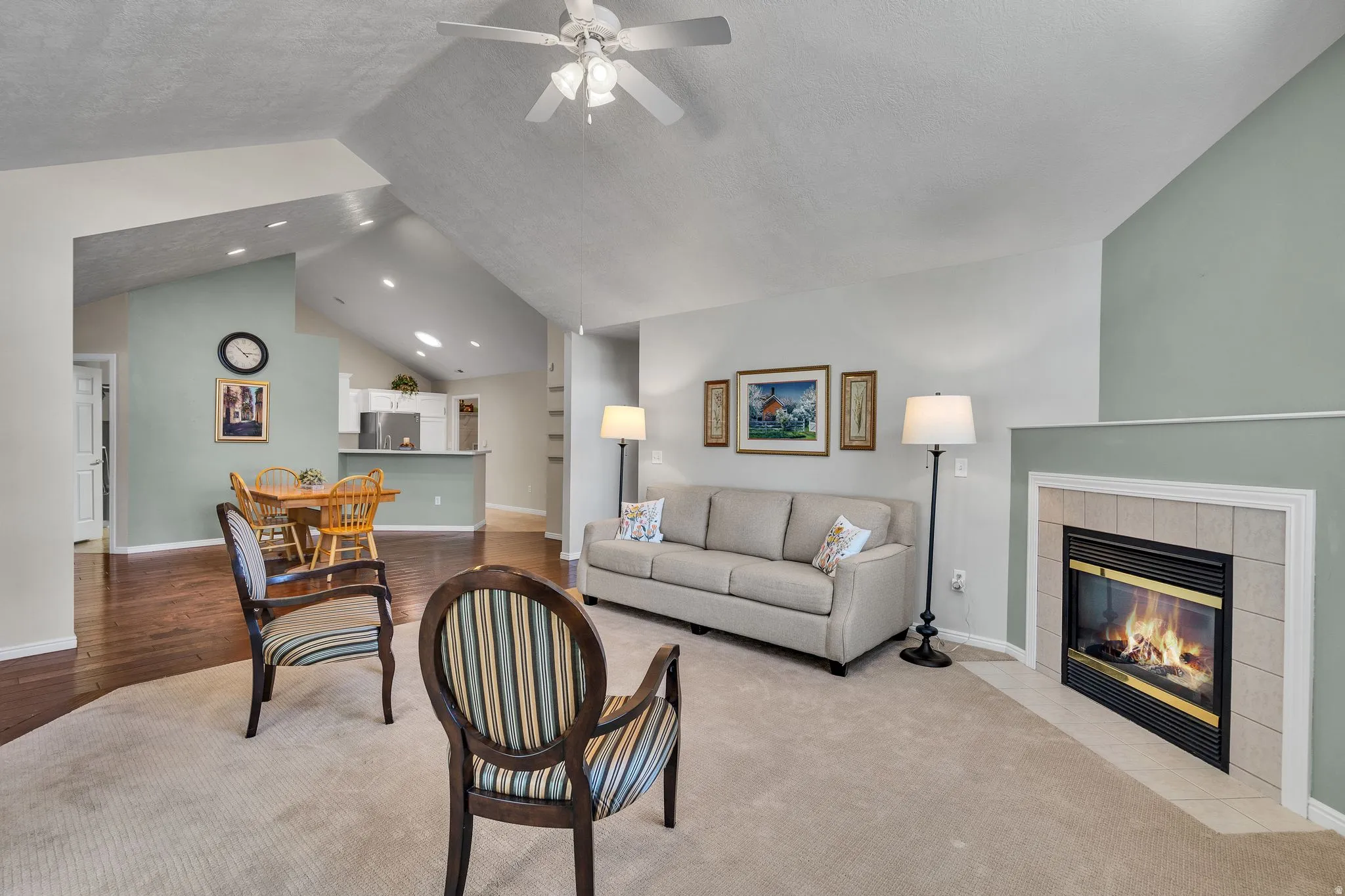 Spacious living area featuring a vaulted ceiling and a ceiling fan
