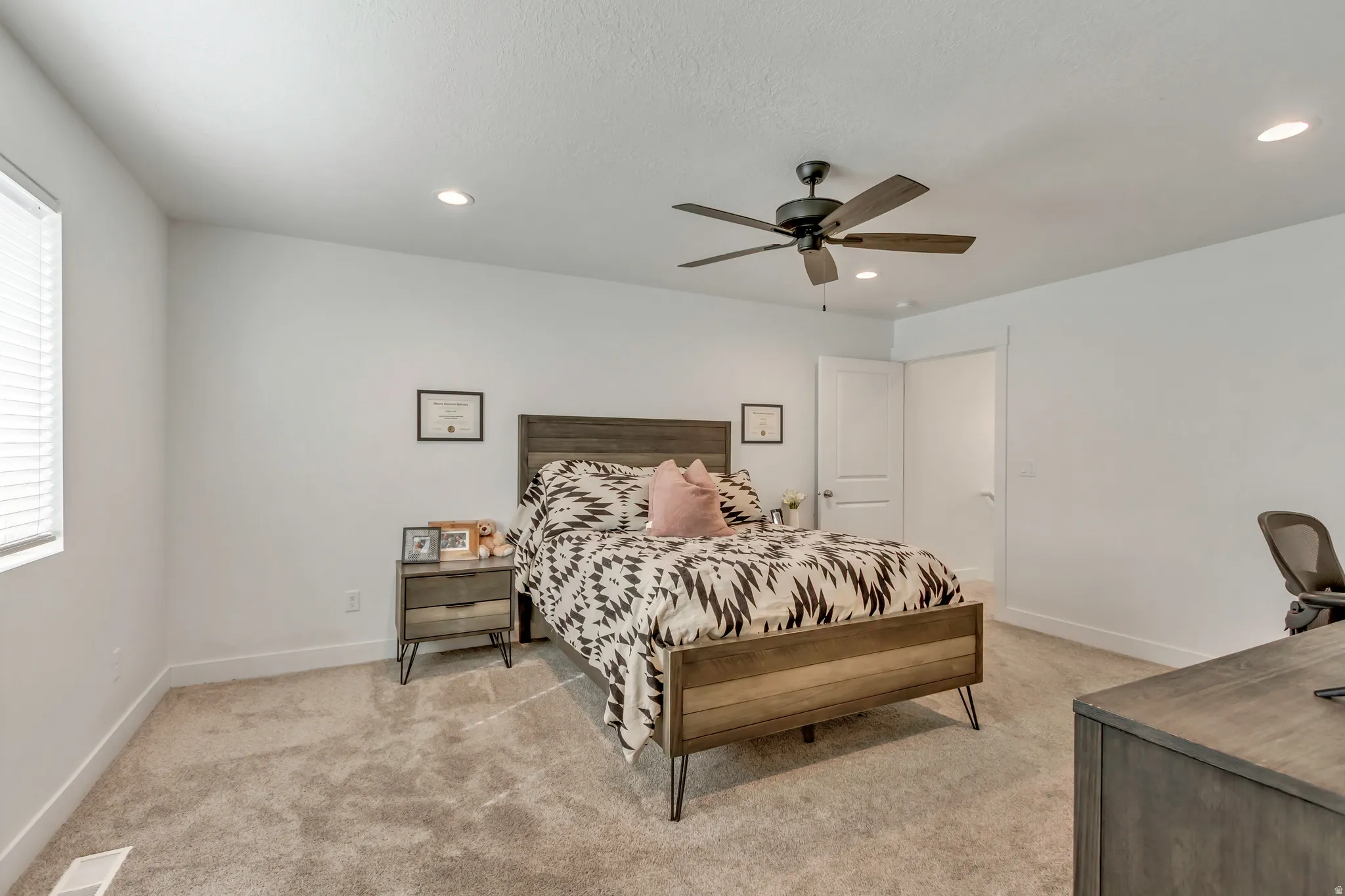 Spacious room featuring neutral carpeting, recessed lighting, and a ceiling fan
