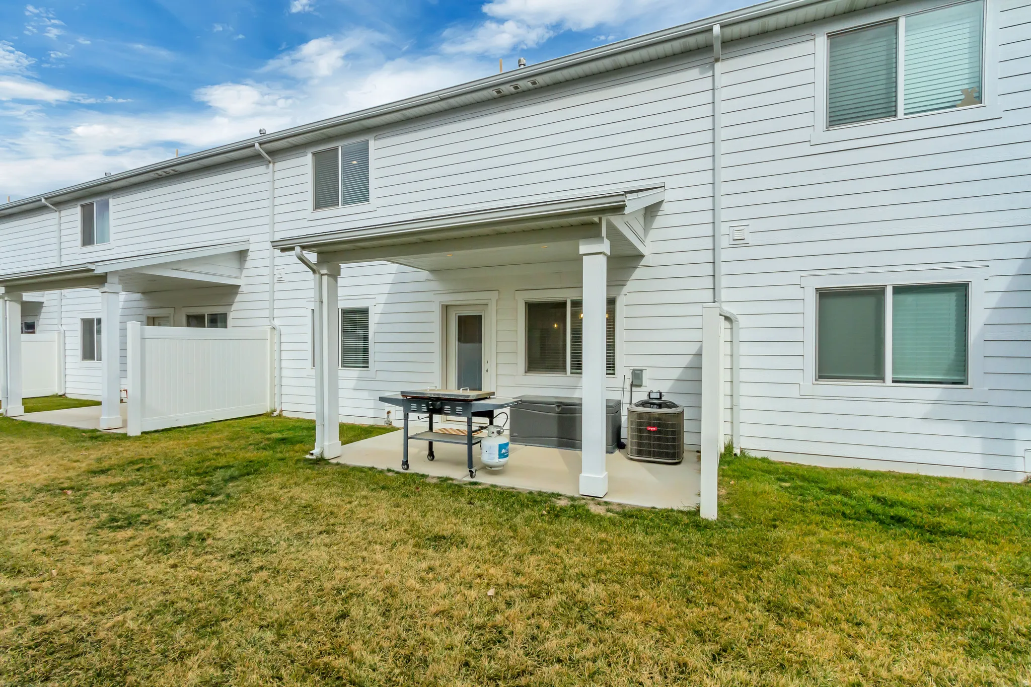 Private patio featuring a concrete surface, covered porch, and white vinyl siding