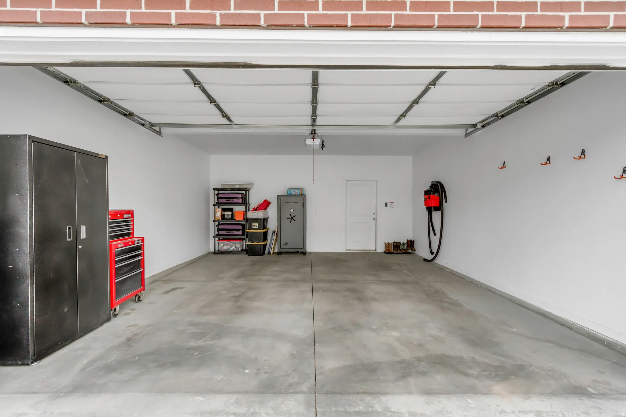 Spacious garage with concrete flooring, white painted walls, and a convenient side access door