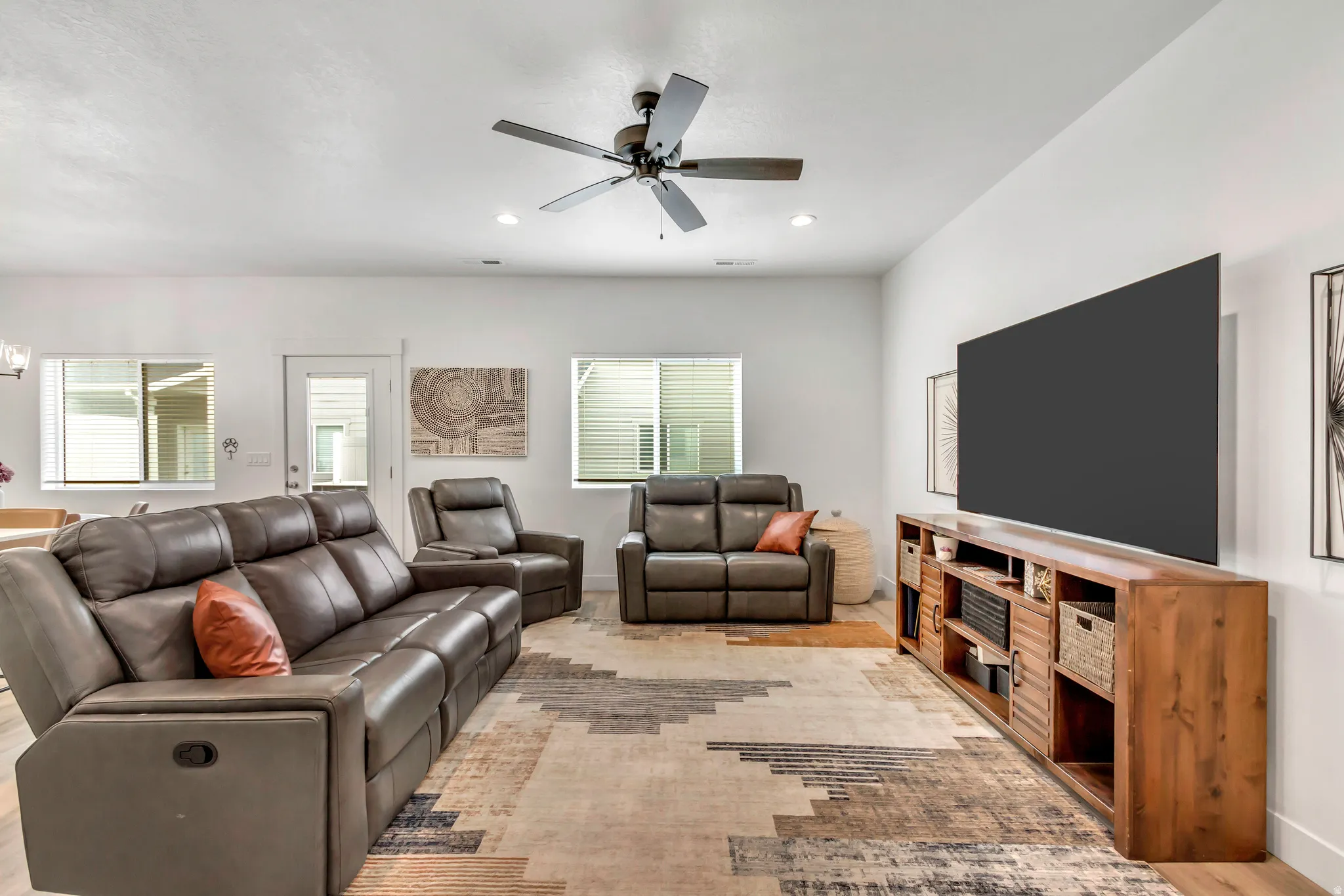 Open concept living space featuring recessed lighting, a ceiling fan, multiple windows with blinds, a white door, and light wood-finish flooring