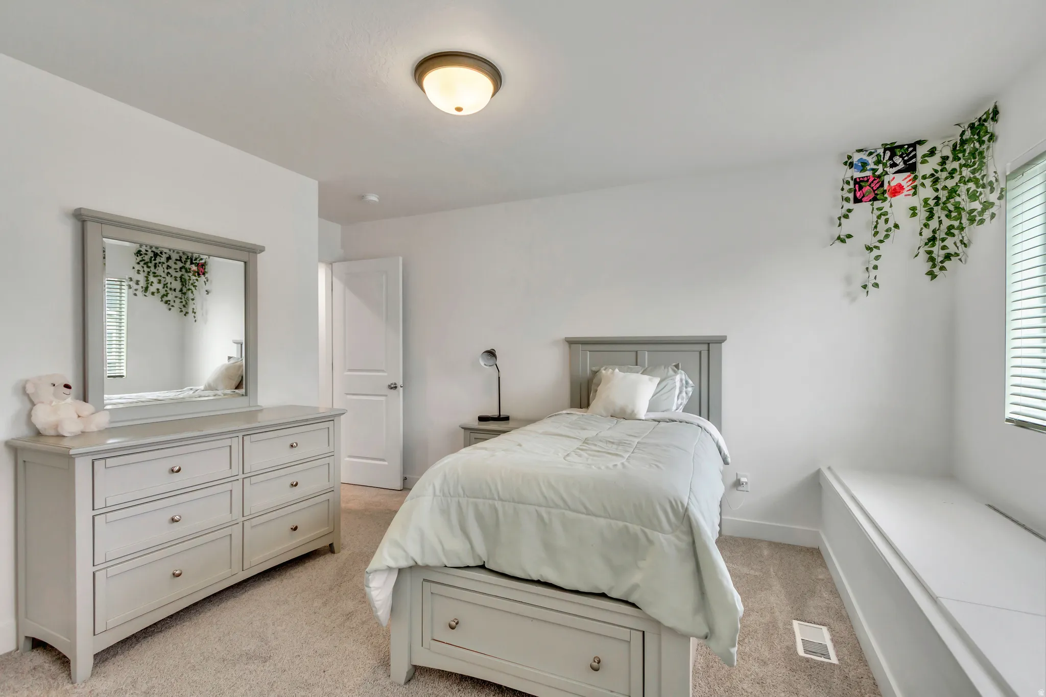 Carpeted interior room featuring light-colored walls and a ceiling-mounted light fixture
