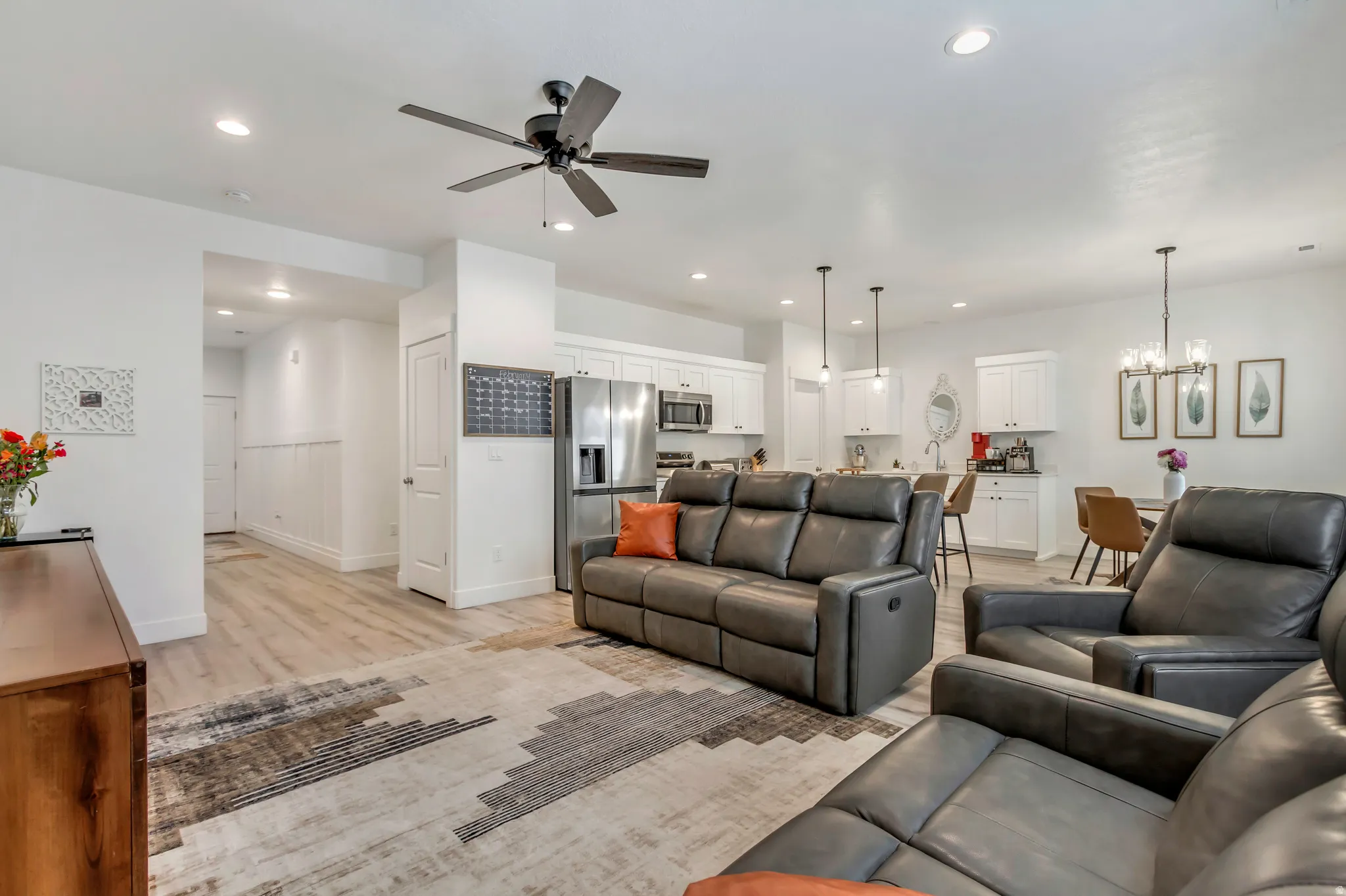 Open-concept living space featuring wood-finish flooring, recessed lighting, and a contemporary ceiling fan