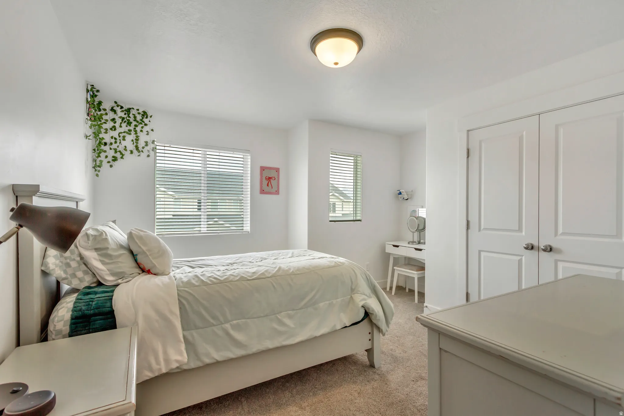 Bright bedroom featuring neutral-toned carpet and white walls