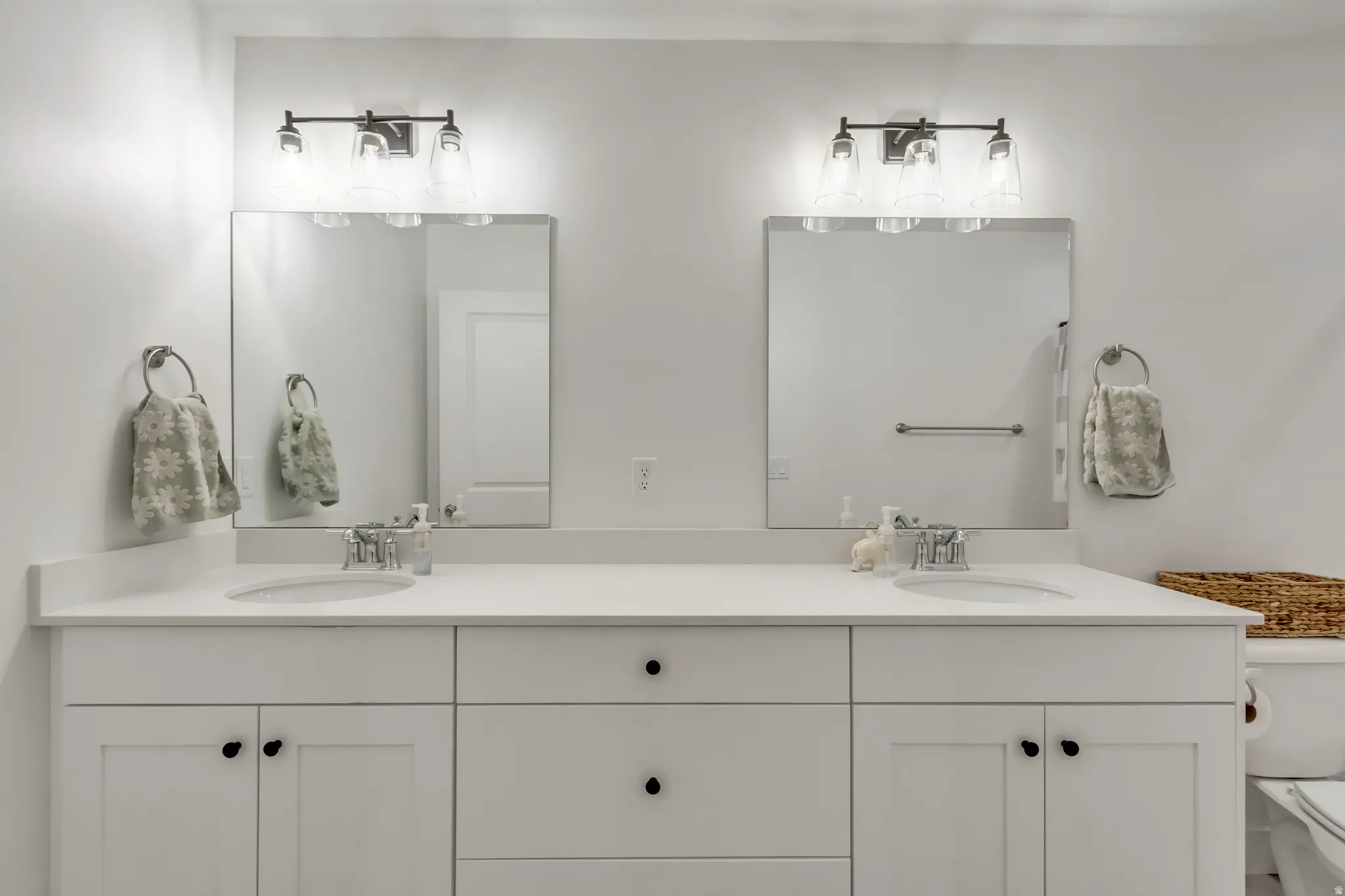 Dual vanity featuring white shaker-style cabinetry, undermount sinks, and polished chrome faucets