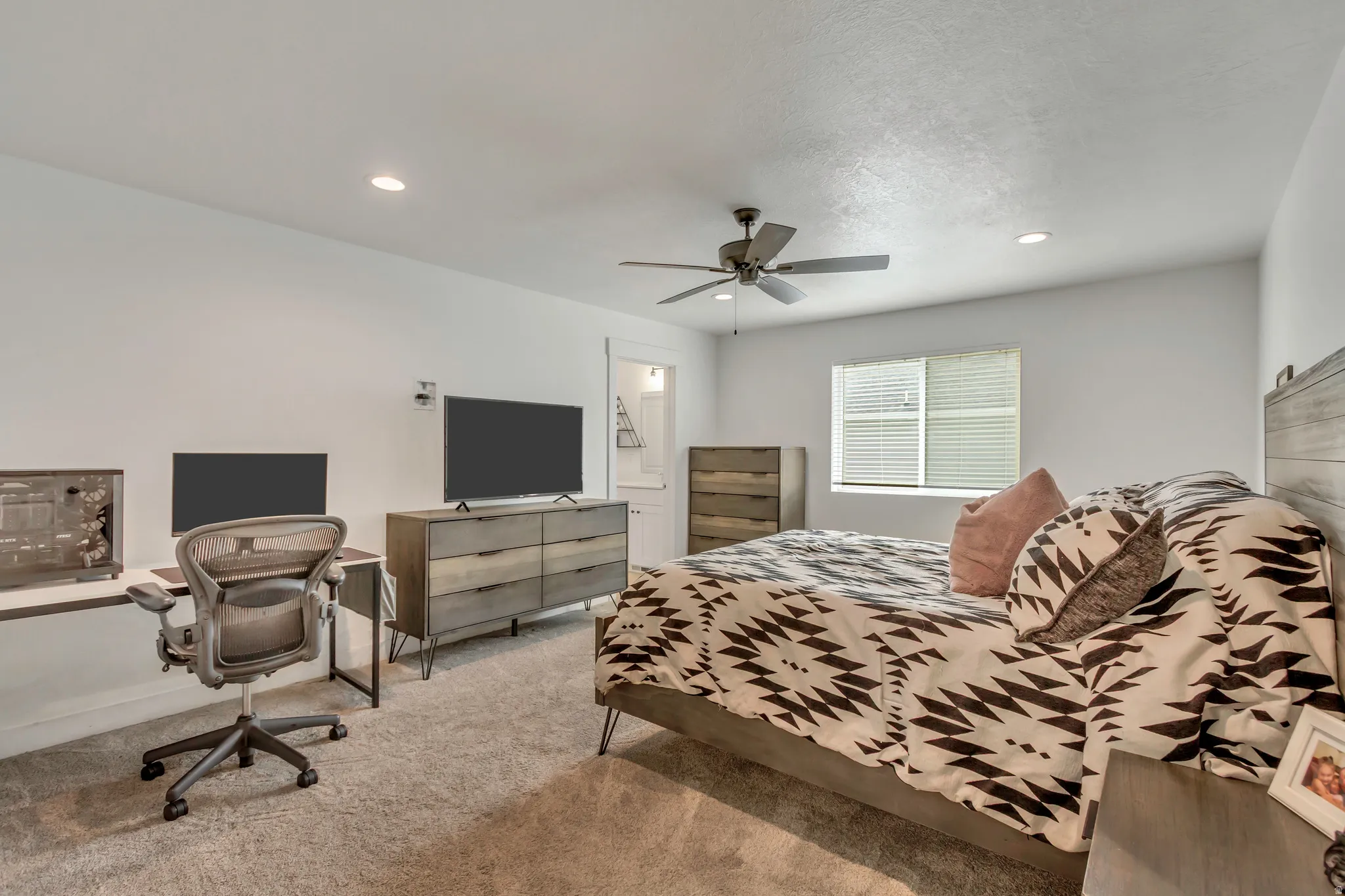 Spacious room featuring neutral carpeting, recessed lighting, and a ceiling fan