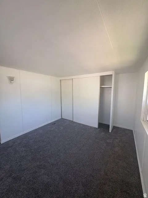 Spacious room featuring new gray carpeting and white panel walls