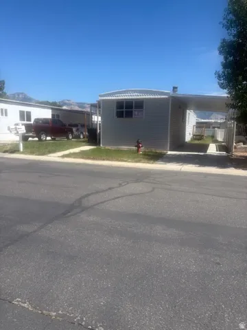 Single-story property featuring light gray vinyl siding and a metal roof