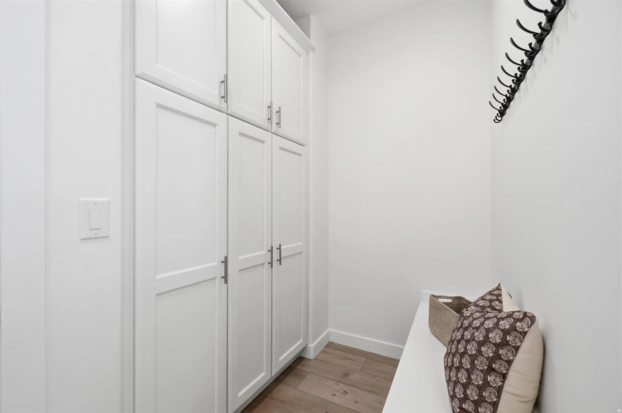 Floor-to-ceiling white shaker cabinetry with brushed nickel hardware