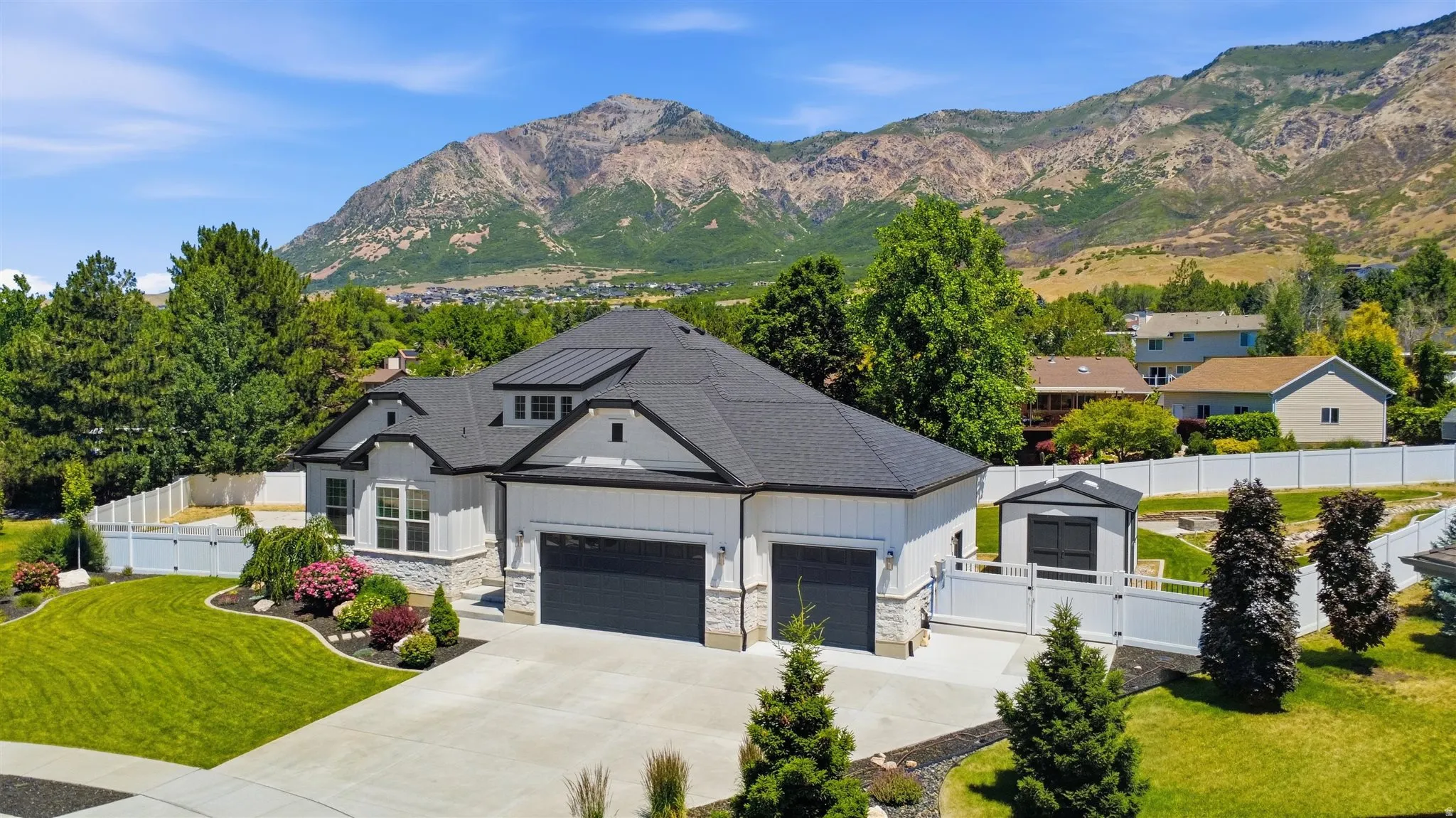 Modern farmhouse exterior with dark roofing, light siding, and stone accents