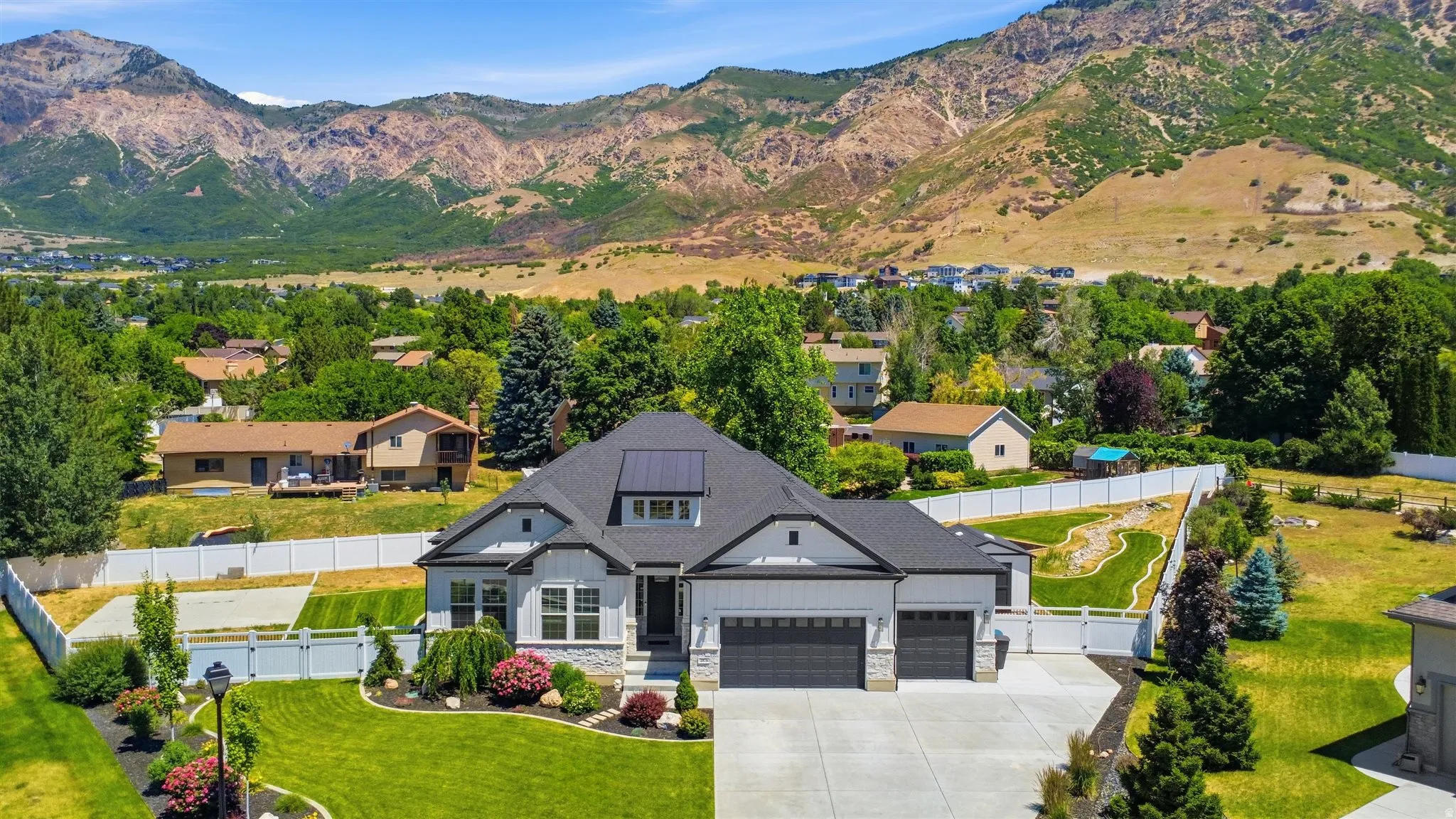 Contemporary home with a dark shingle roof, solar panels, a two-car garage, and a manicured front lawn