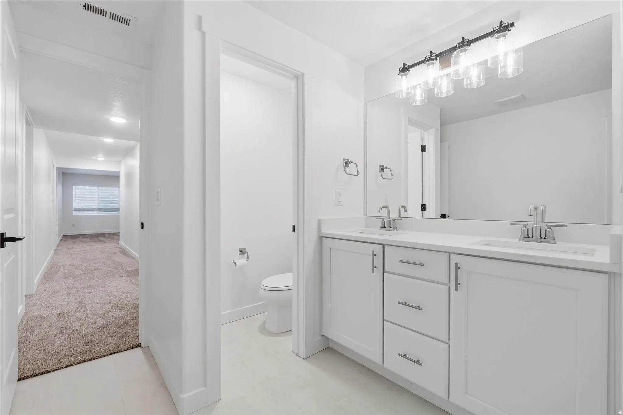 Double vanity with white cabinetry and integrated sinks