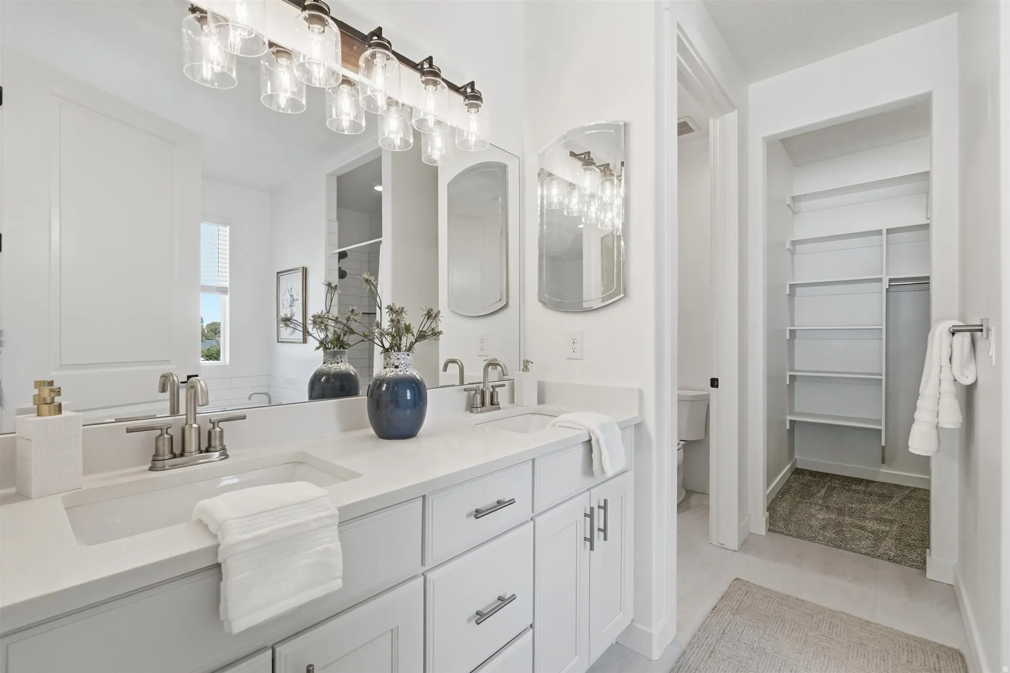 Double vanity featuring undermount sinks, brushed nickel fixtures, and light-toned countertops