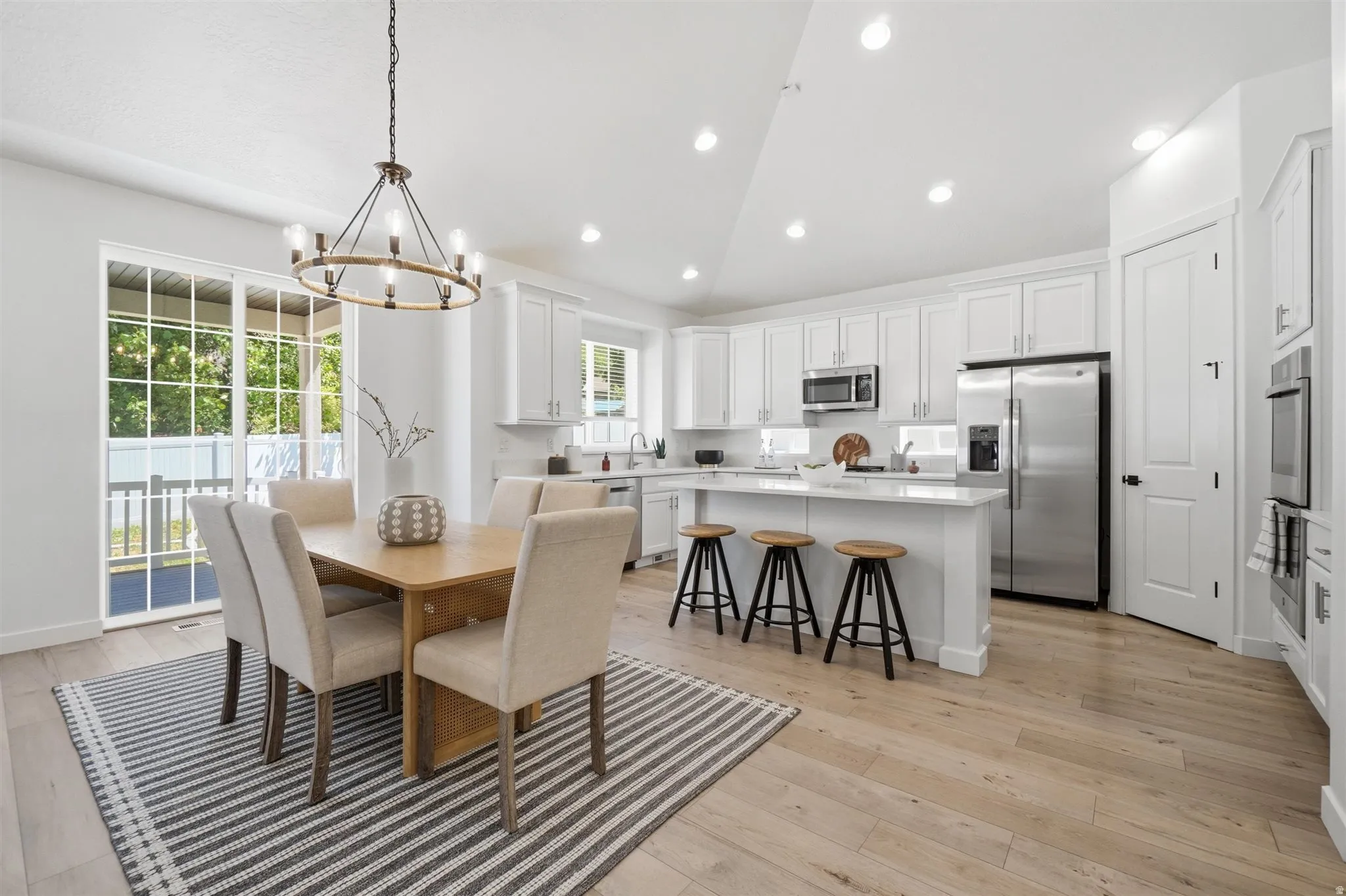 Open-concept kitchen and dining area with light wood-finish flooring