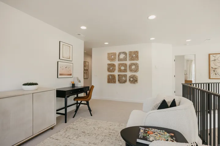 Loft area featuring recessed lighting, light-colored carpeting, and a dark metal railing