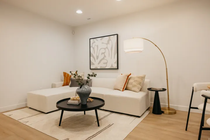 Recessed ceiling lighting illuminates the light-toned walls and wood-finish flooring