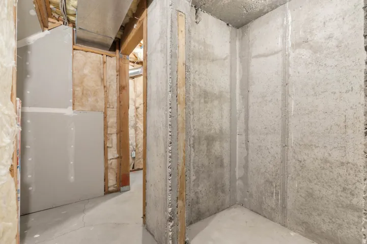 Unfinished basement area featuring exposed concrete walls and flooring