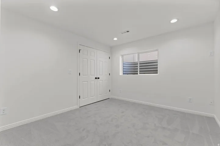 Room featuring light gray carpeting, white walls, and recessed lighting