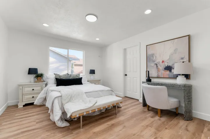 Bedroom featuring wood-finish flooring, recessed lighting, and a window with blinds