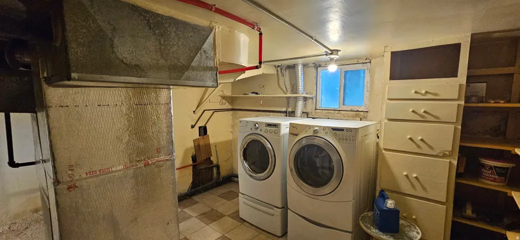 Utility space featuring tile flooring, exposed ductwork, and a small window