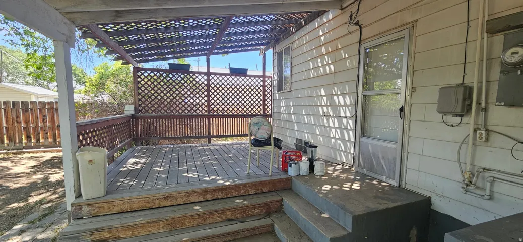 Expansive wood-finish deck featuring a lattice railing and a partial overhead trellis