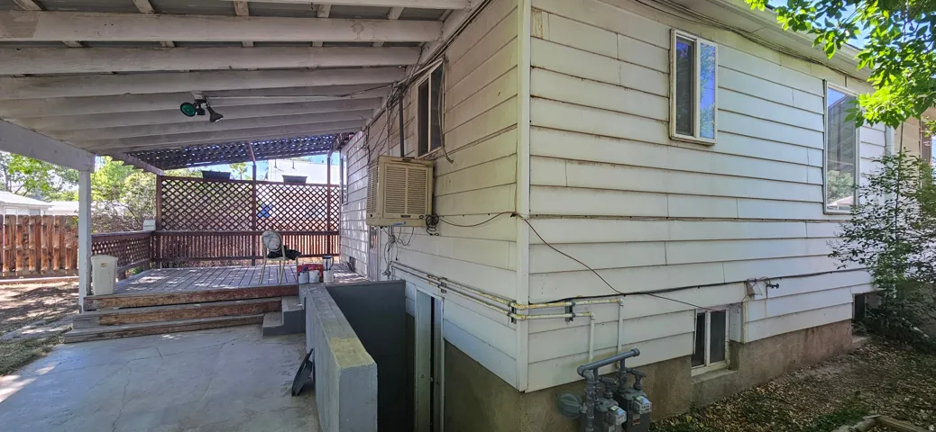 Covered deck with lattice privacy screening, leading to a concrete patio area
