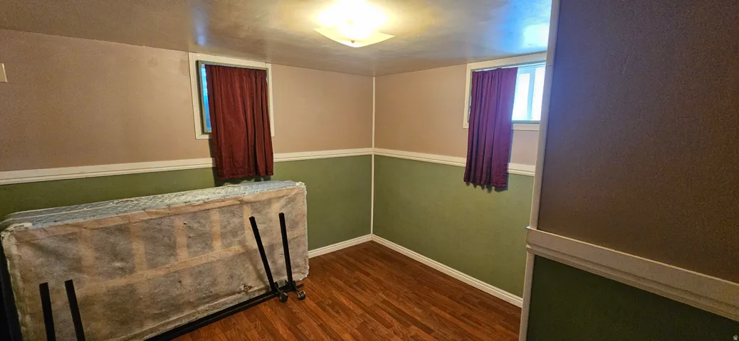 Room featuring wood-finish flooring, two-tone painted walls with chair rail molding, and a flush mount ceiling light fixture