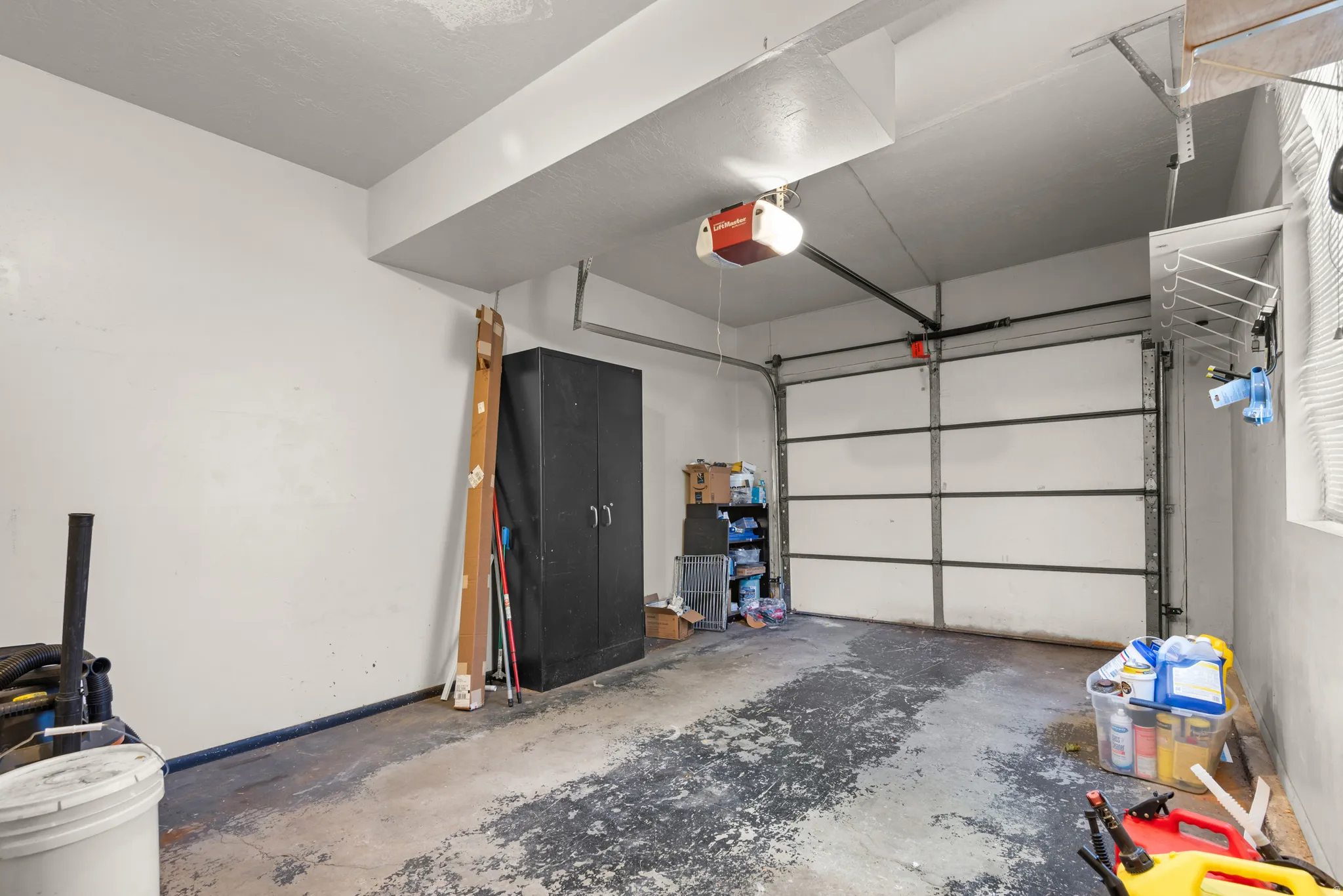 Attached garage with an automatic overhead door and a concrete floor
