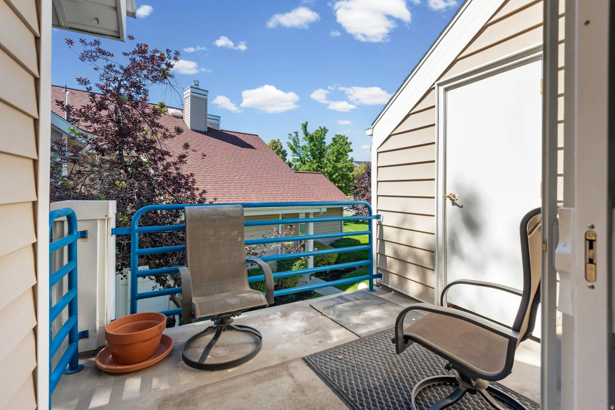 Private balcony featuring a concrete floor, blue metal railing, and a storage shed with horizontal siding