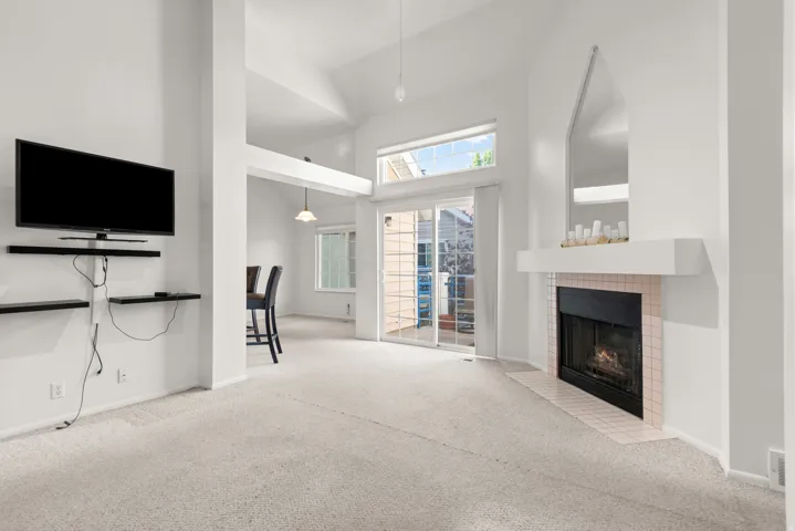 Living area featuring a fireplace with a tiled surround, a white mantel, and a mirrored accent