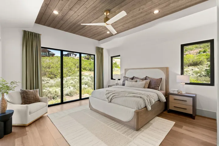 Spacious room featuring a tray ceiling with wood-finish paneling, a contemporary ceiling fan, and recessed lighting