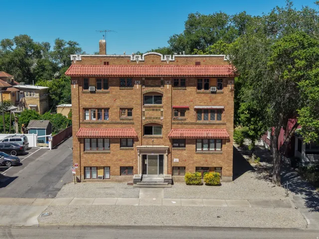 Brick exterior building featuring red tile roofing and decorative parapet
