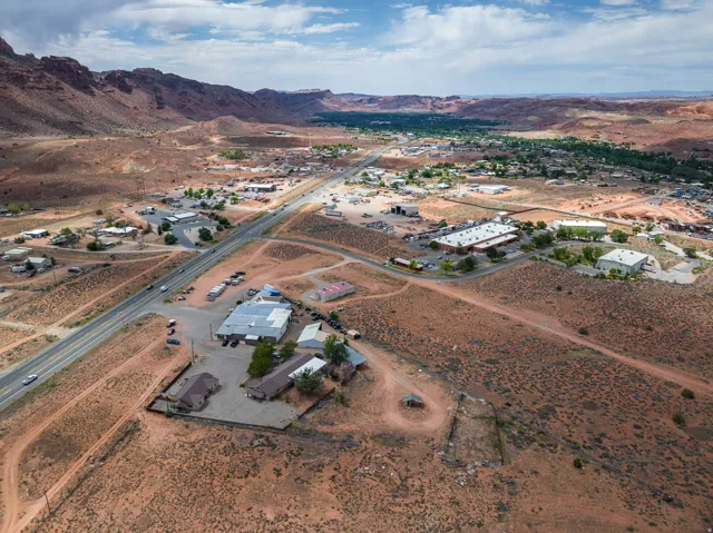 Expansive property featuring multiple structures, a paved road, and a large unpaved area
