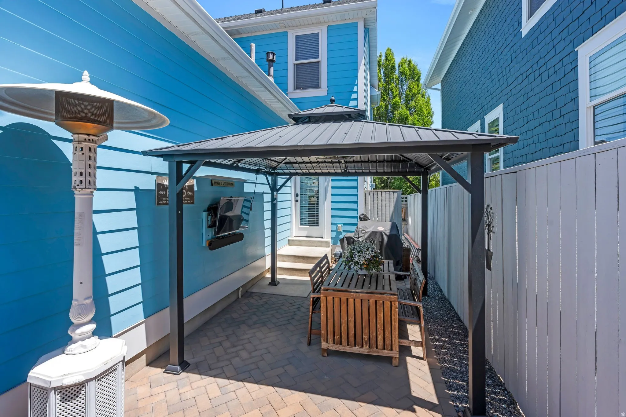Patio area featuring paver flooring, a metal gazebo structure, and a perimeter fence