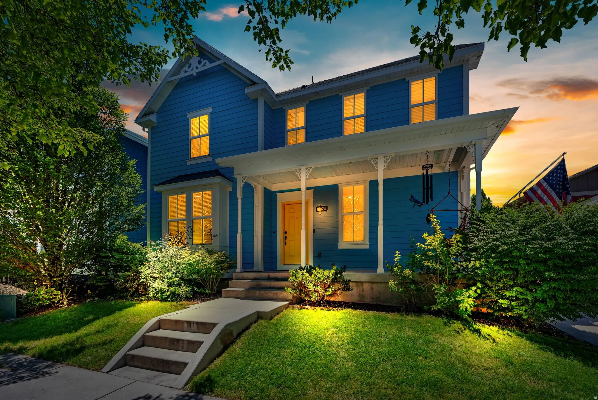 Blue two-story residence featuring a covered front porch with decorative columns