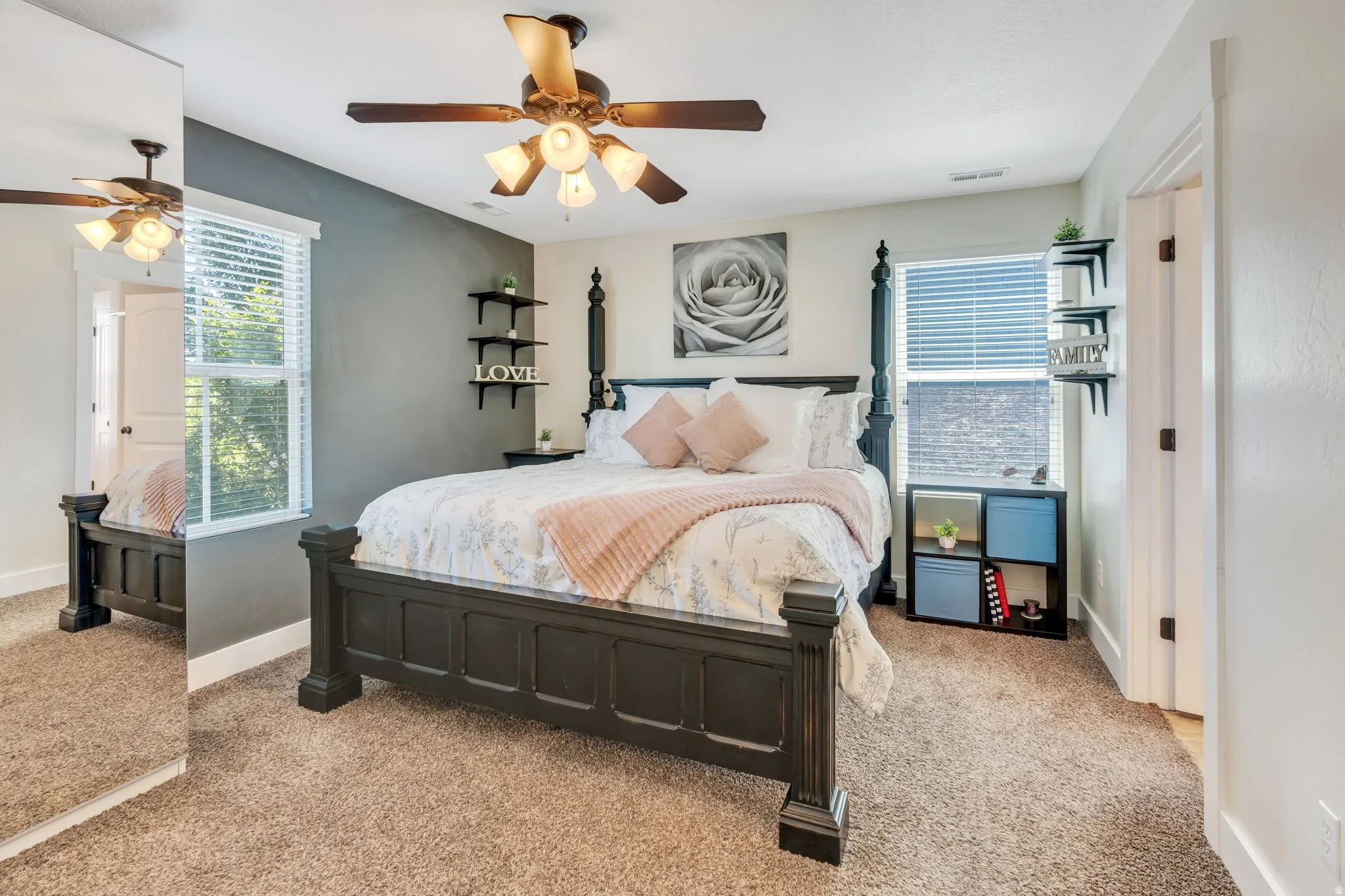Bedroom featuring a textured accent wall, ceiling fan with integrated lighting, and carpet flooring