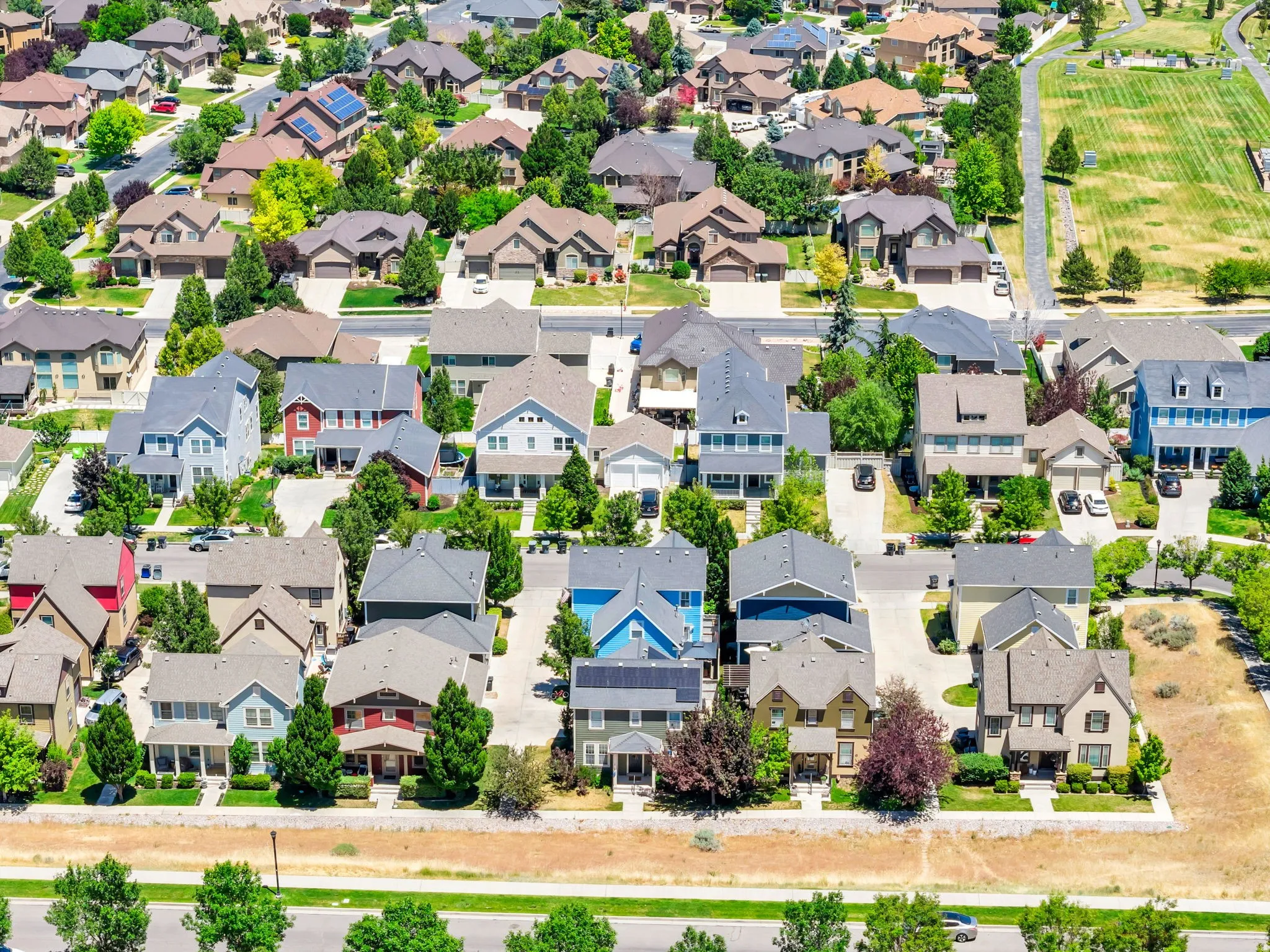 Aerial perspective showcasing a residential development with diverse architectural styles, mature landscaping, and an organized street layout