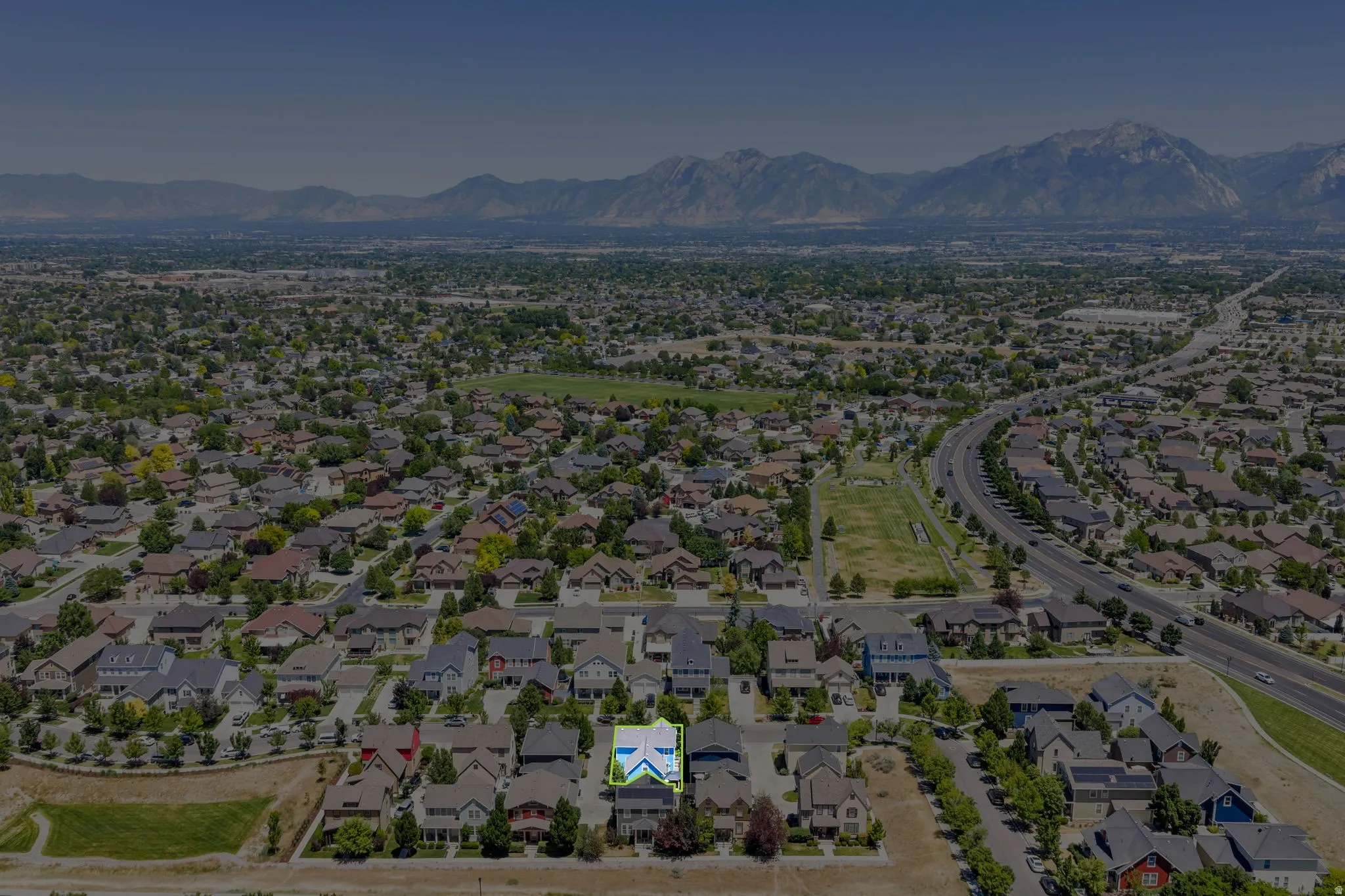 Aerial perspective showcasing a residential neighborhood with distant mountain ranges