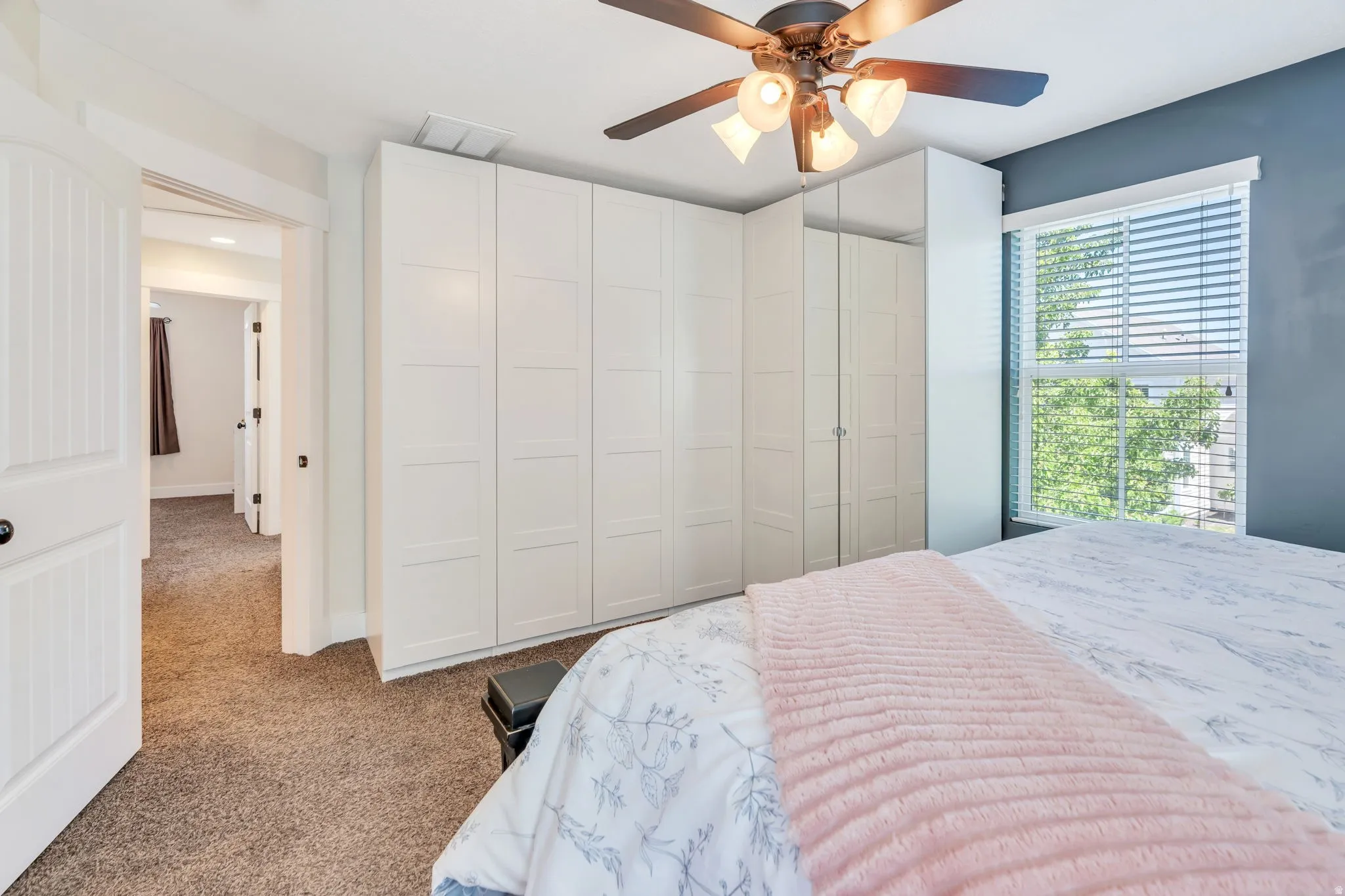 Expansive white built-in cabinetry with mirrored doors provides ample storage