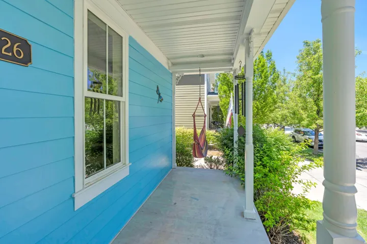 Inviting covered front porch with white columns and a concrete floor