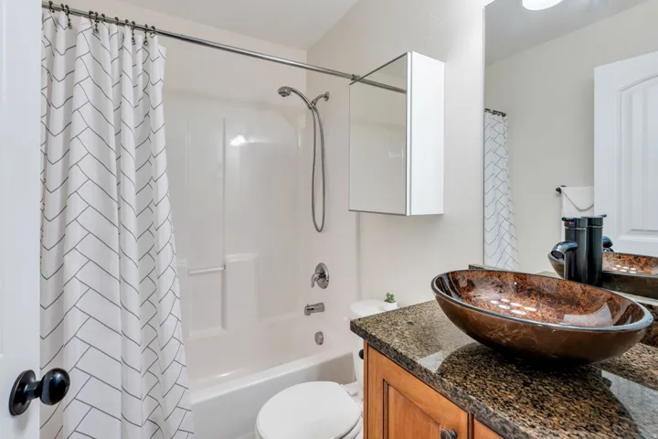Bathroom featuring a built-in tub and shower combination with a shower head and handheld sprayer