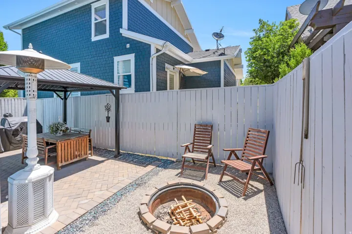 Outdoor patio featuring paver stone flooring, a built-in fire pit with brick surround, and a covered pergola