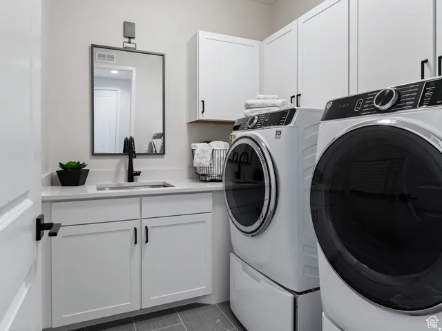 Utility room featuring white cabinetry, a sink with a matte black faucet, and light-toned countertops