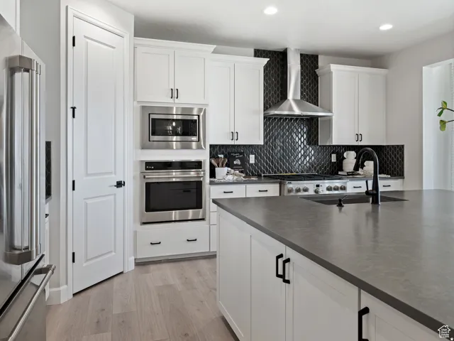 Kitchen featuring white cabinetry, wood-finish flooring, and a dark stone countertop