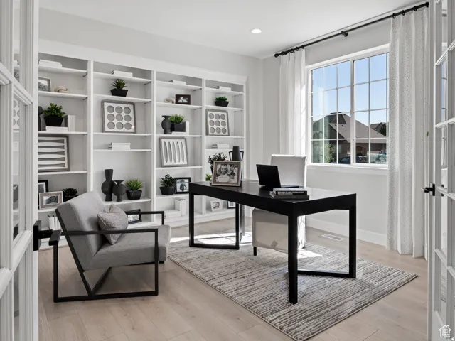Built-in shelving with recessed lighting, large window with grid pattern, wood-finish flooring, French doors with glass panels, and ceiling-mounted lighting