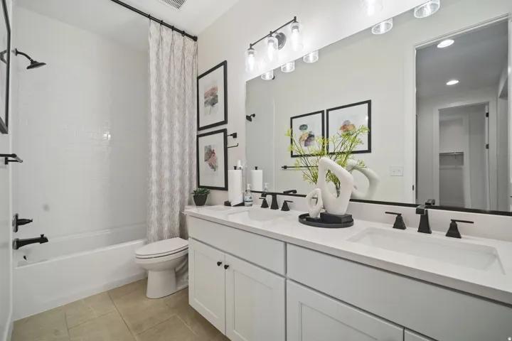 Dual vanity featuring white shaker cabinetry and integrated sinks with matte black fixtures