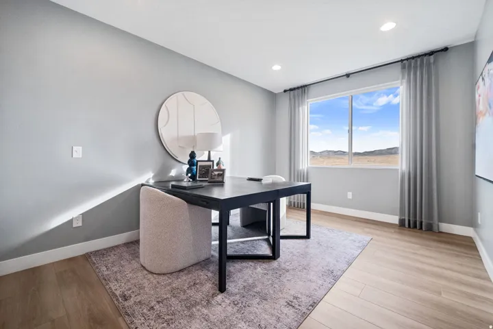 Dedicated room featuring light wood-finish flooring, a large window offering expansive natural scenery, recessed lighting, and a neutral wall color