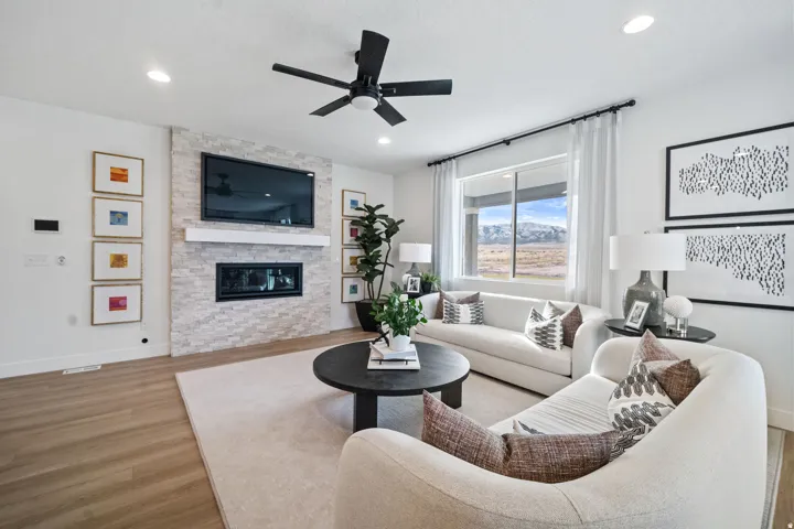 Living area with wood-finish flooring, recessed lighting, and a ceiling fan