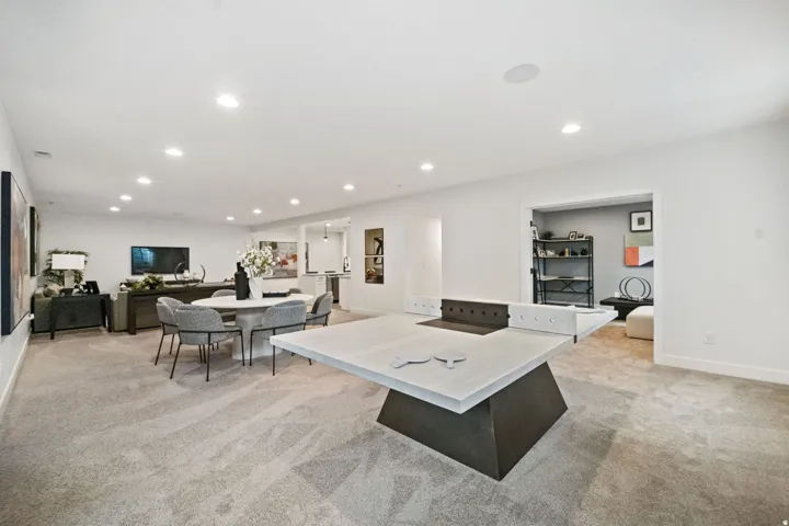 Open-concept recreation area featuring recessed lighting, light-toned carpeting, and a built-in speaker system